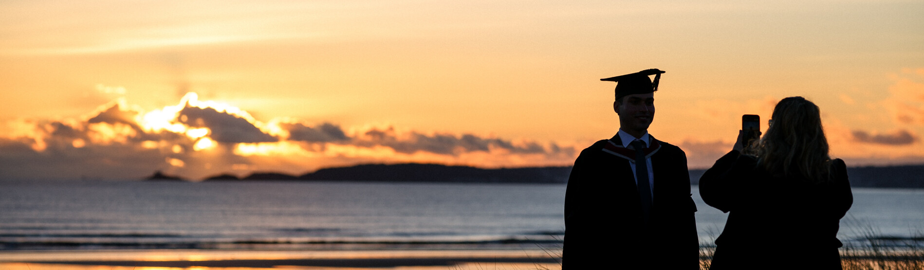 Rhiant yn cymrud llun o myfyriwr. 