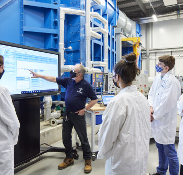 student in the wind tunnel lab with technician