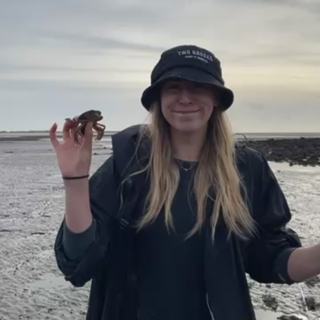 Amelia holding a crab on the beach