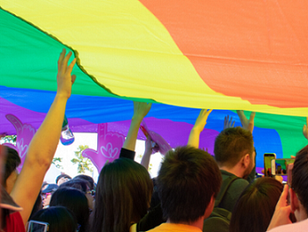Students holding up a large piece of rainbow fabric
