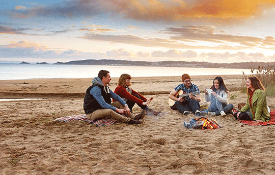A group of students sitting on the beach.