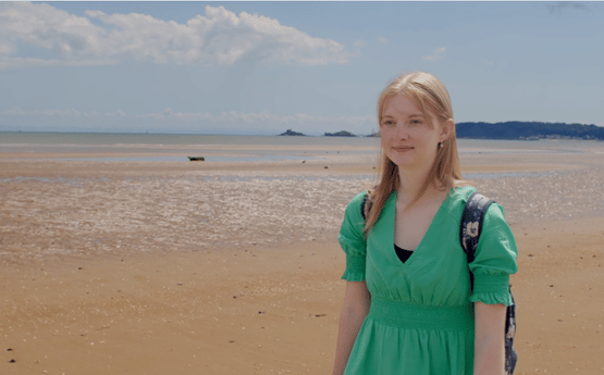 Cara, yn cerdded ar y traeth. 