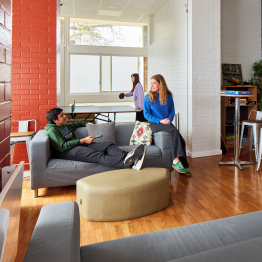 Delwedd o fyfyrwyr yn eistedd yn yr ardal gyffredin yn y llety myfyrwyr ar Gampws Singleton.