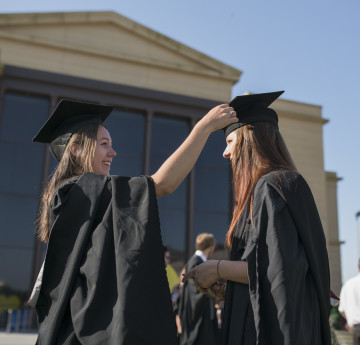 girl putting a graduation cap on girl