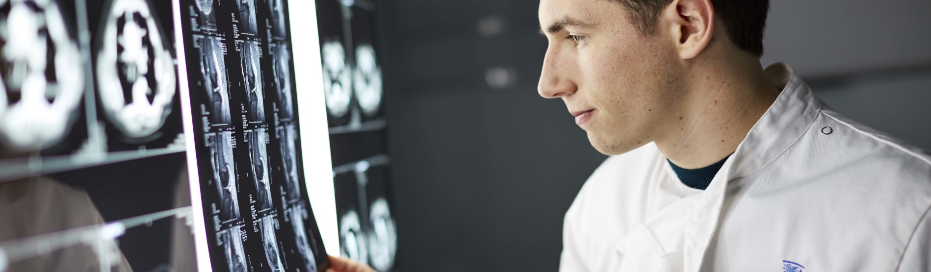 Myfyriwr meddygol yn edrych ar luniau pelydr X