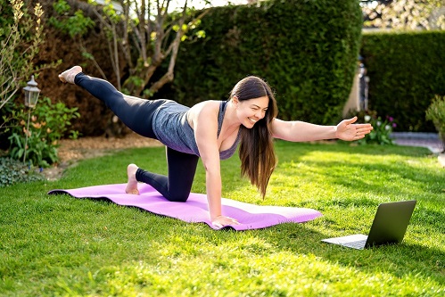 a woman holding a yoga pose on a yoga matt