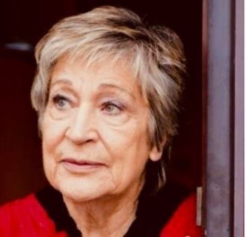 Menyw yn edrych i ochr y camera