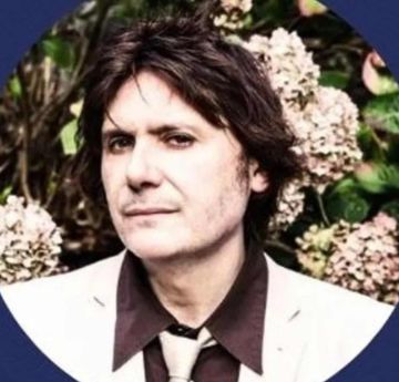 Man standing in front of flowers looking at the camera