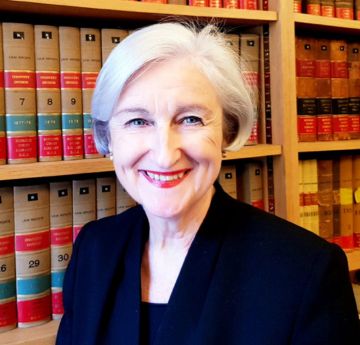 Lady in a library smiling at the camera