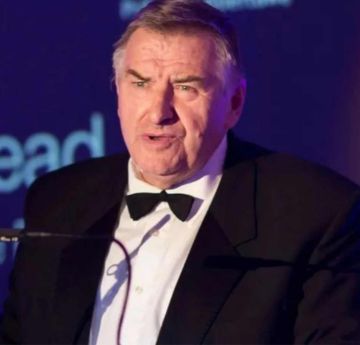 Dyn mewn crys yn siarad mewn digwyddiad