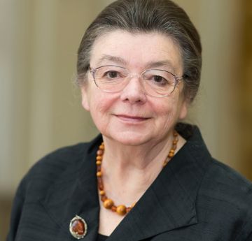 Menyw yn gwisgo du yn gwenu i'r camera