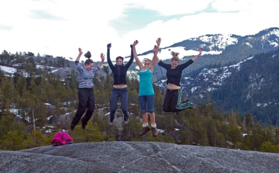 Students jumping on rock