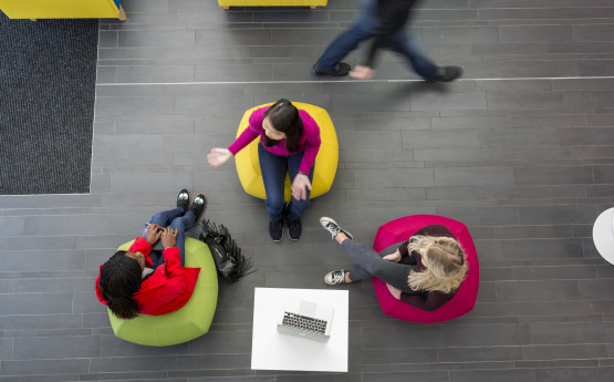 Overhead shot of three students chatting on beanbags