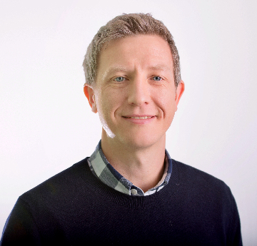 Llun o'r Athro Matthew Davies mewn siwmper ddu