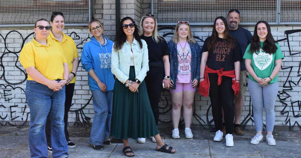 Lella Nouri standing with students in front of project artwork