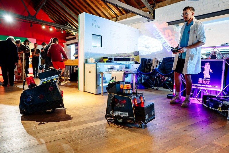 Dyn yn rheoli robotiaid