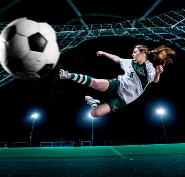 Female student kicking football