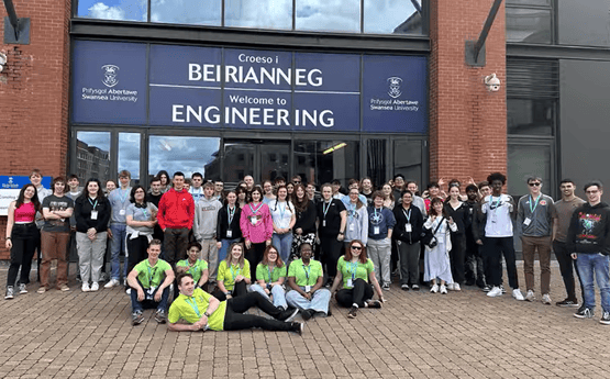 Disgyblion tu allan i adeilad ar campws.