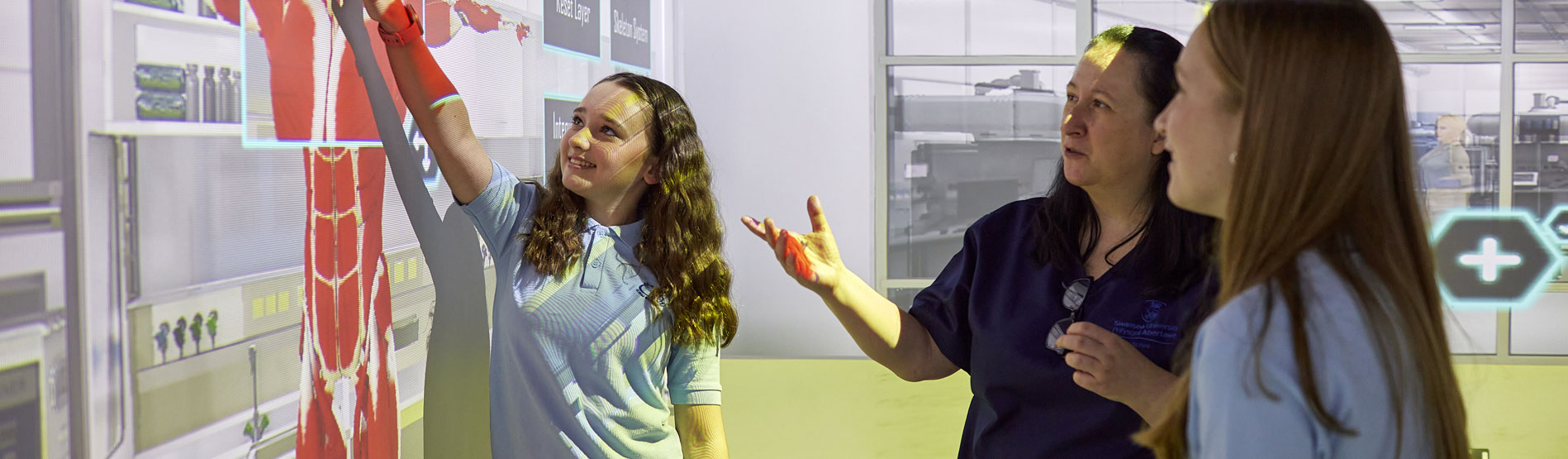 Myfyrwyr yn rhyngweithio gyda wal