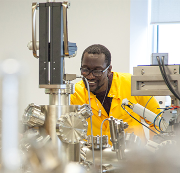 Ymchwilydd yn defnyddio offer yn y Ganolfan NanoIechyd 