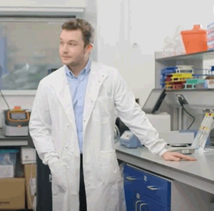 Male scientist wearing white lab coat standing in a laboratory