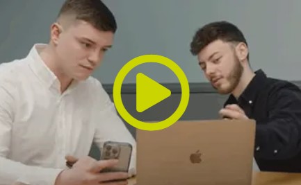Two young men looking at laptop together discussing project