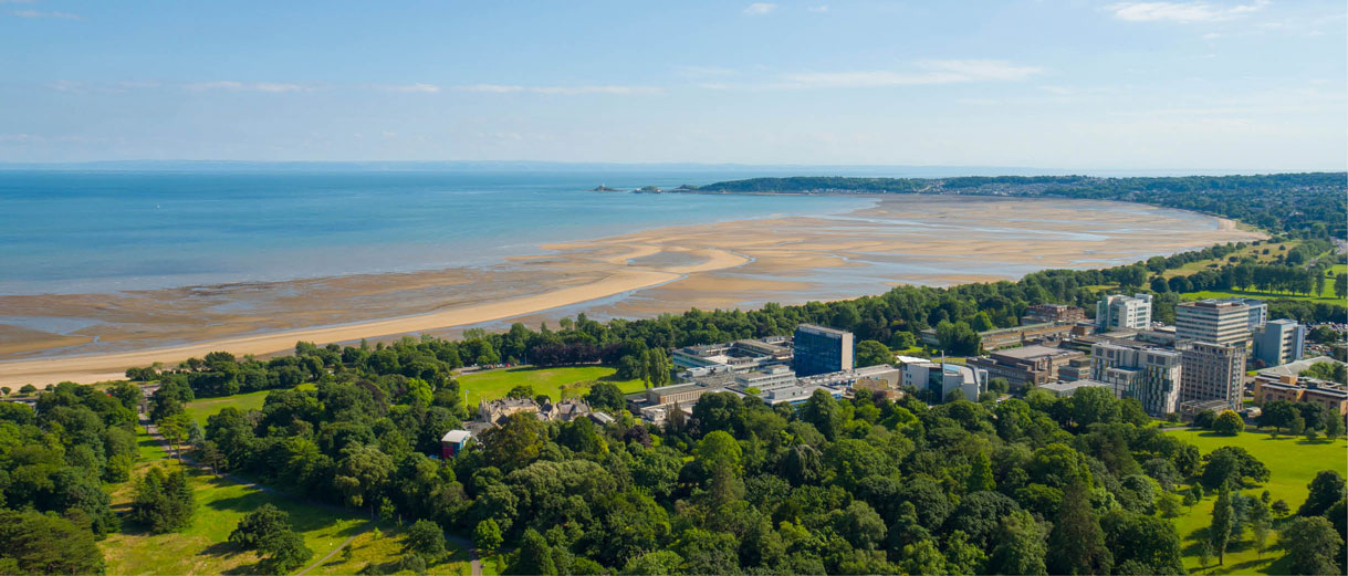 A view of singleton campus including singleton park and the beach, with the sea stretching out to the horizon.