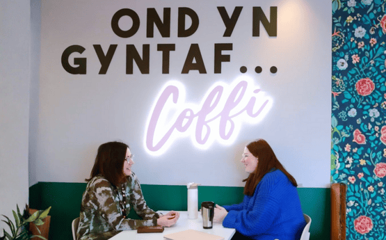 Myfyrwyr yn trafod mewn caffi