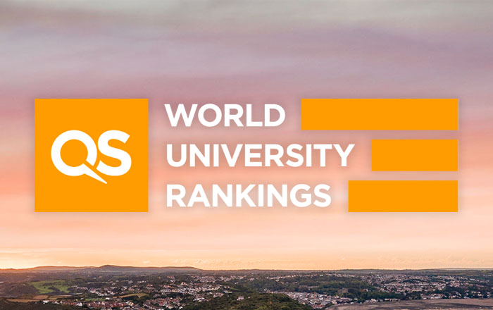 Llun o Abertawe o'r awyr gyda'r testun yn dangos QS World University Rankings. 