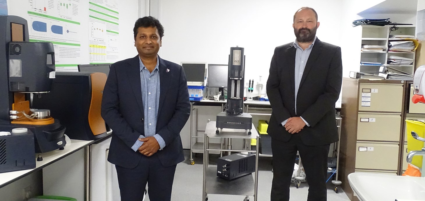 Dau ddyn yn sefyll mewn labordy