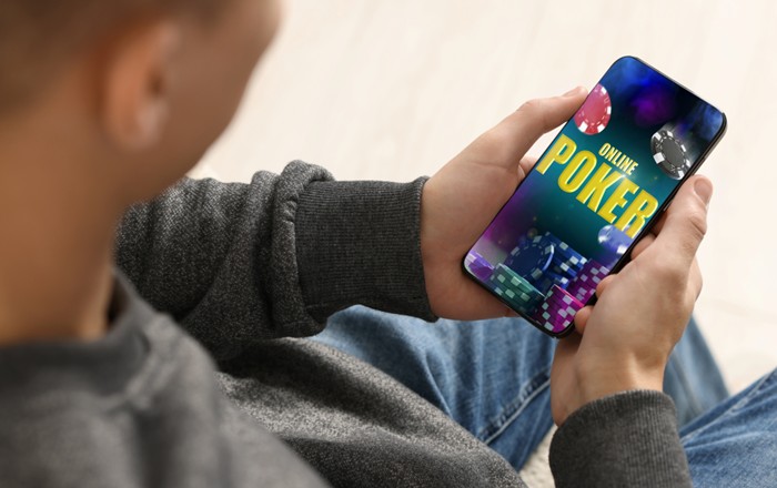 Dyn yn gamblo ar ffôn symudol