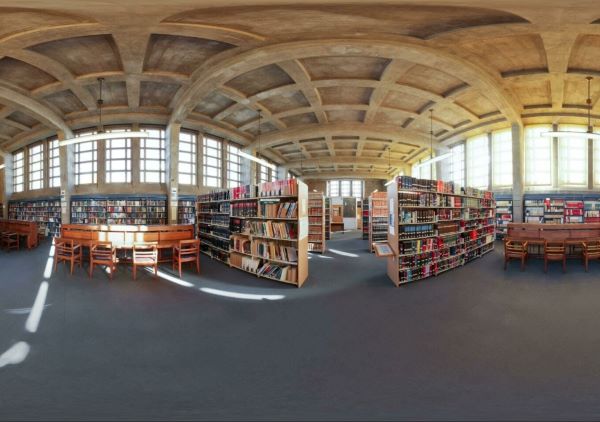 Llyfrgell gyfraith panoramig gyda phentyrrau o lyfrau a byrddau astudio