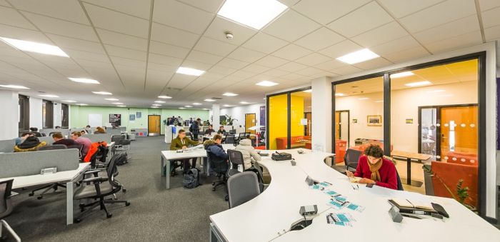 Myfyrwyr yn astudio ac yn cydweithio mewn gofod dysgu cynllun agored