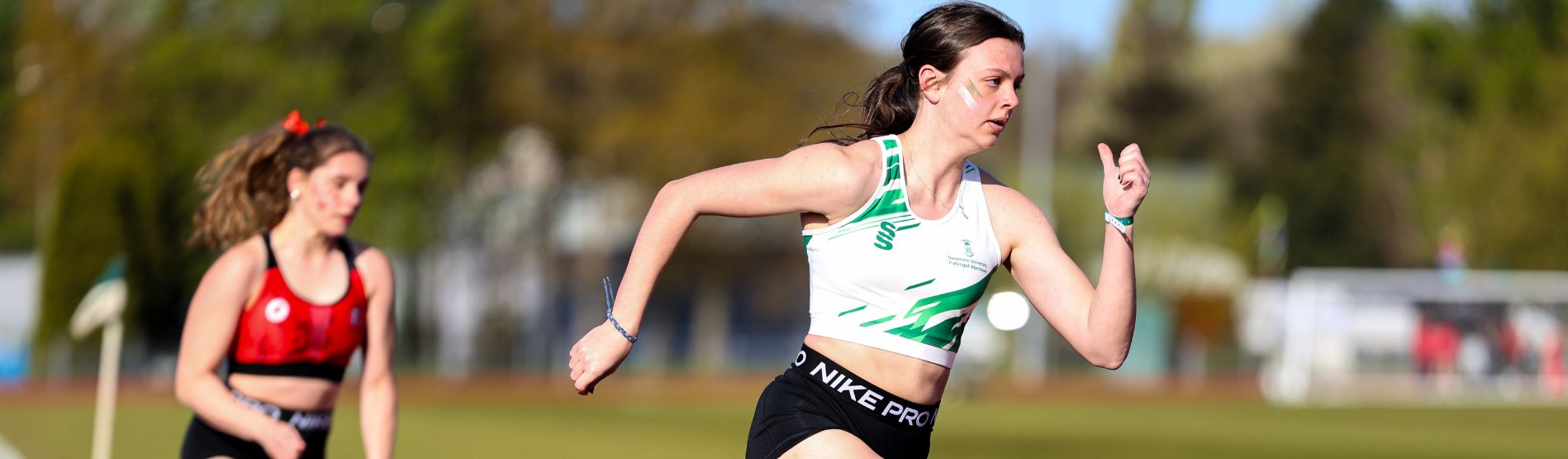 Myfyriwr yn sbrintio yn ystod digwyddiad Varsity Cymru