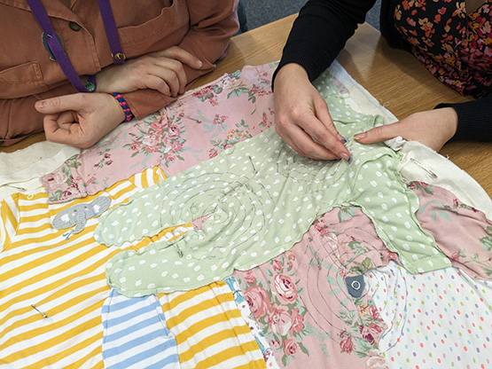 Pobl yn gwneud cwilt