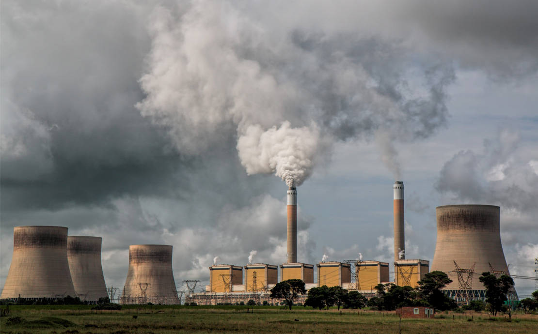 A series of industrial chimneys exhausting gases