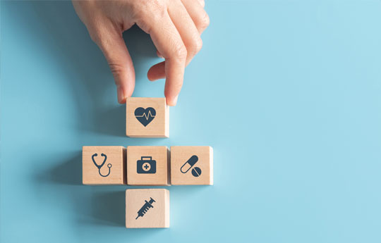 llaw yn gosod 5 bloc pren gyda delweddau iechyd arnynt