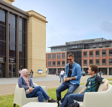 students sitting outside great hall in bay campus