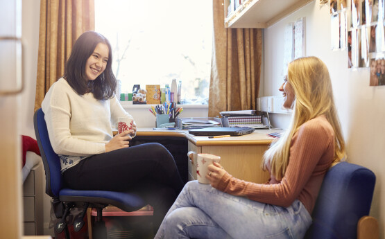 Two students chatting in a dorm room
