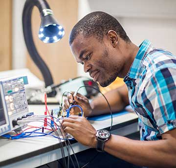 Student working with electronics equipment in laboratory