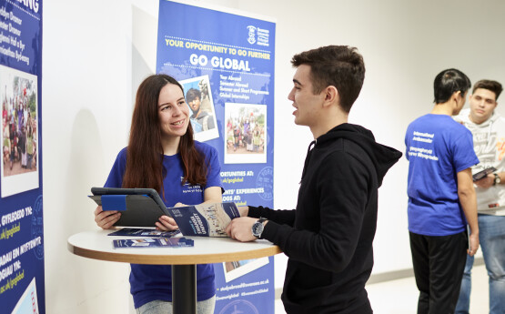 Students talking in front of Go Global blue banner