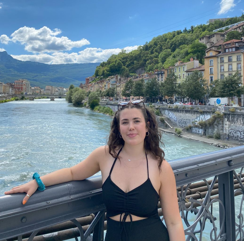 Student in Lyon standing on bridge. 
