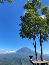 student sat on some decking looking out at the mountains