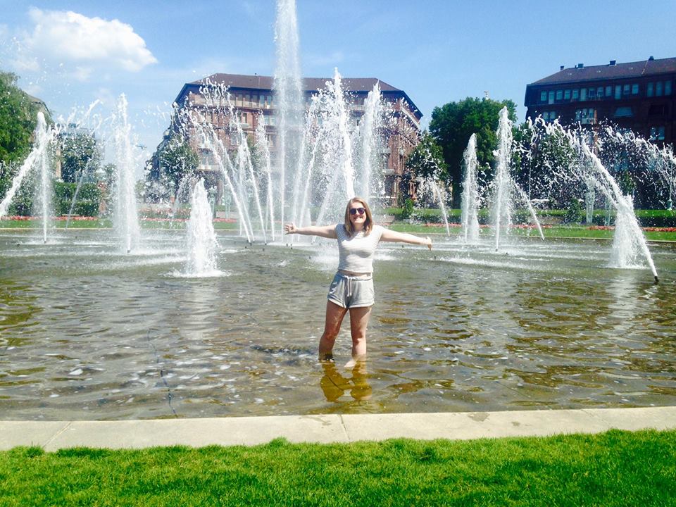 Female student having fun in water fountain