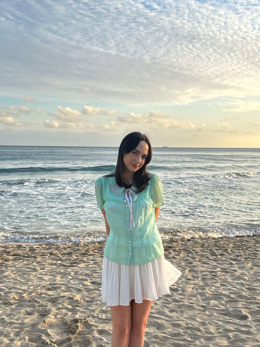 Laura in Busan in front of the beach on a sunny day.