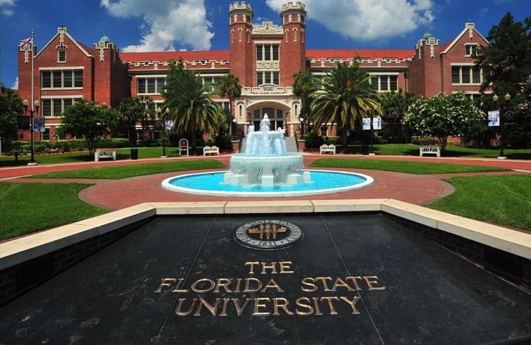 Red brick building with a fountain in front of it at Florida State University 