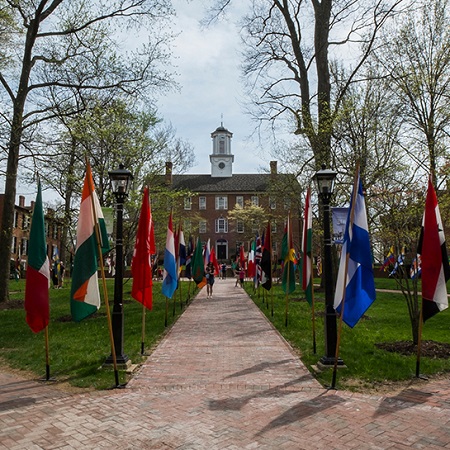 Walkway up to a campus building lined with flags of various countries