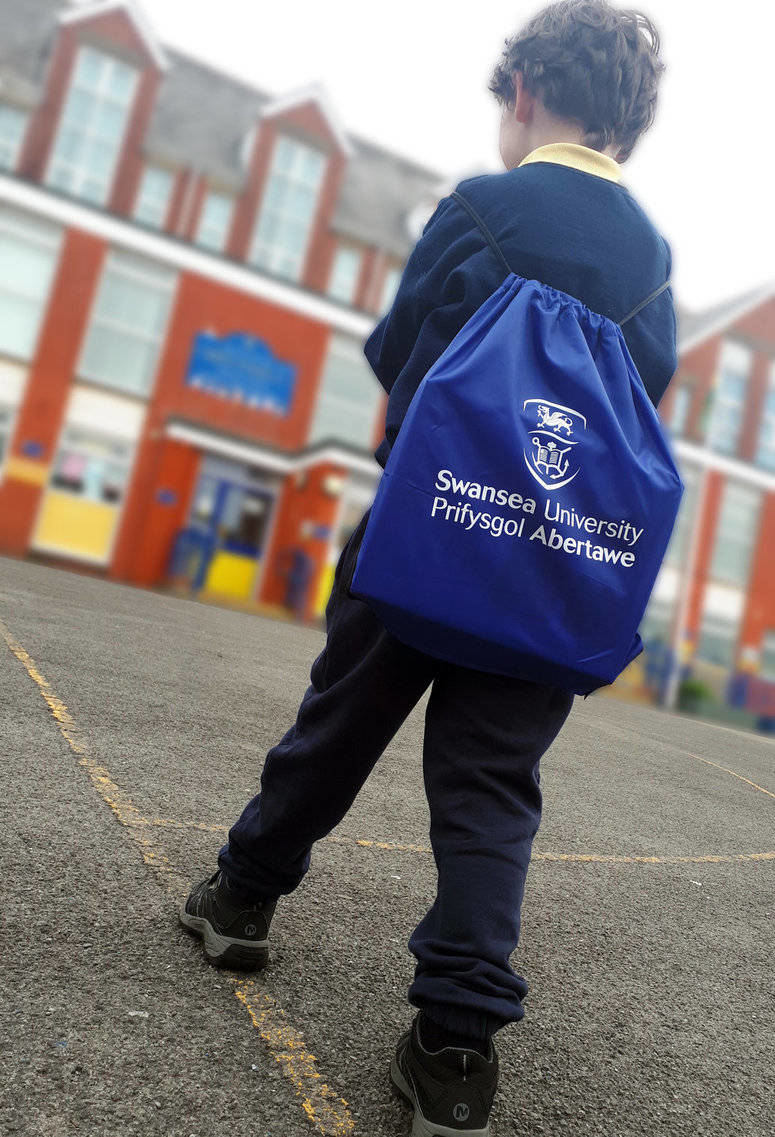 Child with Swansea University Bag walking into School