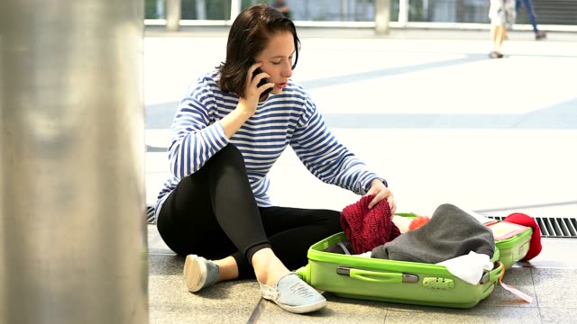 Woman searching an open suitcase and not finding what she is looking for