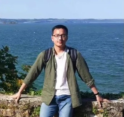 student smiling standing by the sea